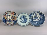 trois assiettes bleues et blanches ornées de motifs variés
