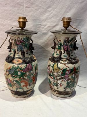 pair of chinese vases with floral designs on them sitting on a white surface
