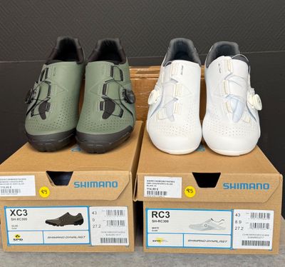 trois paires de chaussures posées sur des cartons, sur une table