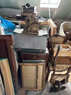 un chat assis sur une chaise à côté d'une pile de livres