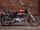 a red and black motorcycle parked in front of a brick wall
