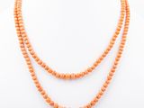 an orange beaded necklace on a mannequin mannequin