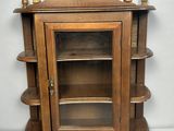 a wooden cabinet with a glass door and shelves