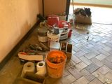 Il y a quelques seaux de peinture posés par terre dans une pièce.