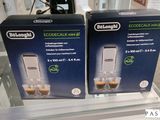 deux cartons contenant des machines à expresso De’Longhi exposés dans un magasin