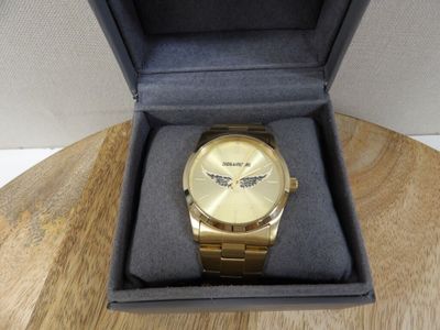 une montre en or dans un coffret posé sur une table en bois