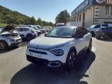 la voiture blanche est garée devant un bâtiment dans un parking