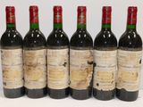 six bottles of wine are lined up in a row on a table