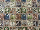 a close up of a patchwork rug on a wooden floor