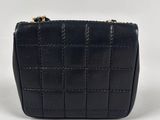 a black leather purse with a gold chain strap