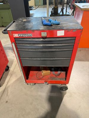 une boîte à outils rouge posée sur une table en métal