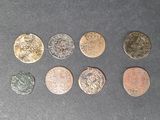 six pièces de monnaie britanniques différentes posées sur une table, sur fond noir