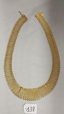 un collier en or sur fond blanc, avec une étiquette de prix