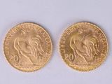 two gold coins, one of which is a rooster and the other of which is a rooster