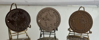 three antique coins are on display in a glass case