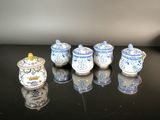 five blue and white teapots on a black table