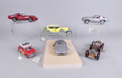 cinq modèles réduits de voitures exposés dans une vitrine