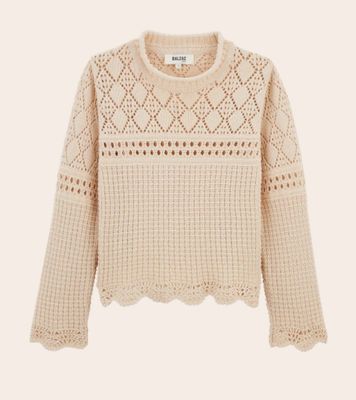 un pull blanc avec un motif au crochet sur les épaules