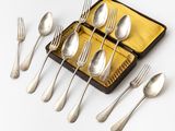 silverware in a case on a white surface with forks and spoons