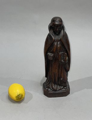 a small statue of a monk next to a yellow ball