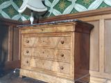 une commode sur laquelle est posée une lampe, dans une pièce