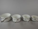 three white buckets with handles are lined up on a gray surface
