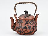 teapot in the shape of a teapot with flowers and leaves on it