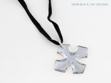 silver cross pendant with black ribbon on a white background
