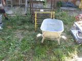 a man that is standing in the yard with a wheelbarrow