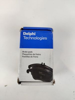 une photo d'une boîte de plaquettes de frein « Delphi Technologies » posée sur une surface blanche