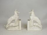 pair of white ceramic dog bookends with a dog sitting on a rock