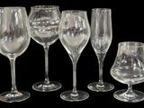 cinq verres à vin vides et un verre à vin à moitié vide