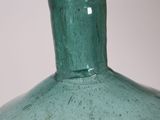 a green vase sitting on a table with a white background