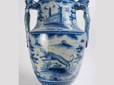 un grand vase bleu et blanc posé sur un socle