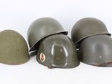 three helmets are lined up in a row on a white surface