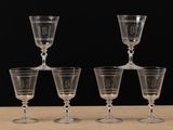 four wine glasses sitting on top of a table next to each other