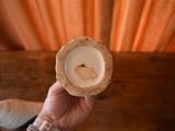 a person holding a candle in their hand on a table