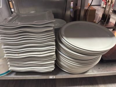 de nombreuses assiettes empilées sur une étagère dans un magasin