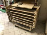 several trays of food sit on top of a cart in a kitchen