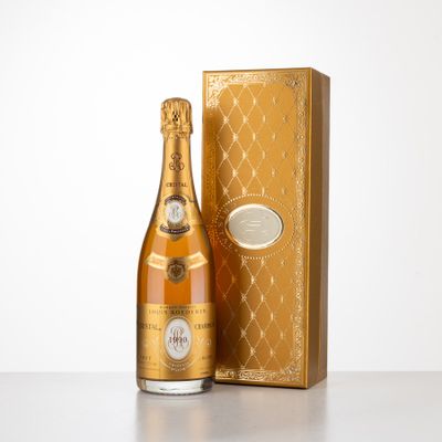 a bottle of champagne in front of a gold box