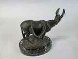 bronze statue of a bull on a marble base on a white background