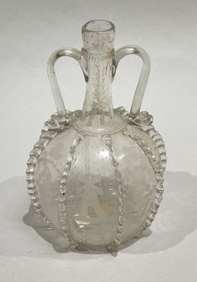 a glass bottle with a handle on a white surface