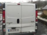 un homme tenant un parapluie, debout à côté d'une camionnette blanche