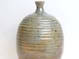 a small vase that is sitting on a white surface