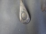 a silver spoon with a picture on it sitting on a table
