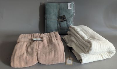three folded towels are sitting on a table next to each other