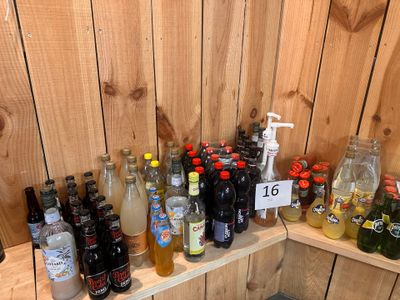 plein de bouteilles, les unes à côté des autres, sur une étagère