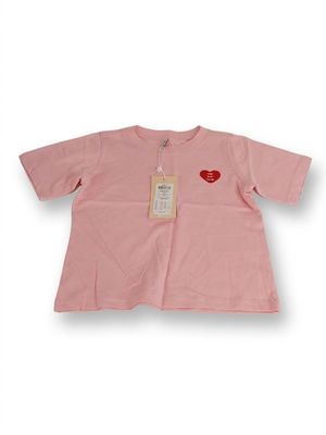 T-shirt rose avec un cœur rouge sur la poitrine et une étiquette