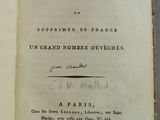 un livre ouvert avec une écriture dessus, posé sur une table