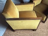 mustard colored chair and ottoman in a living room with a mirror